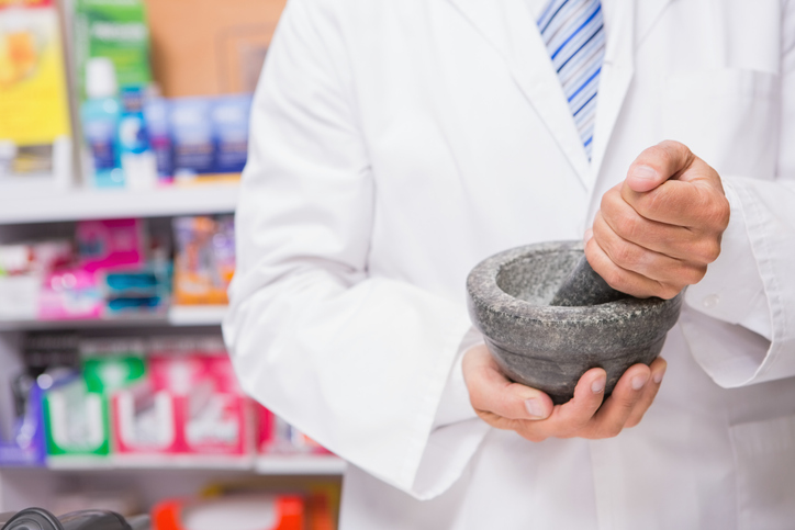 Pharmacist in lab coat mixing a medicine in the pharmacy